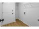 Bright laundry room boasts white cabinets, shelving, and wood-look flooring, offering functionality and style at 1909 Riverlanding Cir, Lawrenceville, GA 30046