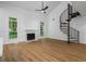Living room featuring a fireplace, spiral staircase, and large windows providing natural light at 1909 Riverlanding Cir, Lawrenceville, GA 30046