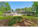 Expansive backyard featuring lush lawn, mature trees, and home exterior with a large window-lined porch at 4265 Hidden Valley Dr, South Fulton, GA 30349