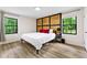 Bedroom featuring wood-look flooring, a rustic wood headboard, and two windows for ample natural light at 4265 Hidden Valley Dr, South Fulton, GA 30349