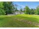 Spacious front yard with stepping stones leading to a charming white house surrounded by mature trees at 4265 Hidden Valley Dr, South Fulton, GA 30349