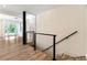 Hallway featuring a modern railing system, wood-look floors, and white trim, transitioning to stairs at 4265 Hidden Valley Dr, South Fulton, GA 30349