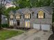 Traditional two-story home featuring a three-car garage and stone facade at 4365 Dover Crossing Dr, Marietta, GA 30066