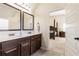 Bathroom featuring double sink vanity, marble countertops, modern fixtures, and entryway to the bedroom at 6280 Stillwood Ln, Cumming, GA 30041