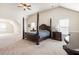 A carpeted bedroom with four-poster bed, side tables and ceiling fan at 6280 Stillwood Ln, Cumming, GA 30041