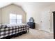Bright bedroom featuring a bed with black and white patterned comforter, a window, and a black dresser at 6280 Stillwood Ln, Cumming, GA 30041