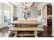 Well-lit dining room showcasing a brick accent wall and a rustic wooden table at 6280 Stillwood Ln, Cumming, GA 30041