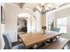 Bright dining room featuring wainscoting, chandelier, and a rustic wooden table at 6280 Stillwood Ln, Cumming, GA 30041