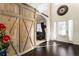 Bright foyer featuring hardwood floors, a decorative sliding barn door, and elegant wainscoting detail at 6280 Stillwood Ln, Cumming, GA 30041