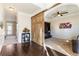 Stylish foyer with hardwood floors, barn door, and archway leading to a cozy living space and a sunlit carpeted room at 6280 Stillwood Ln, Cumming, GA 30041