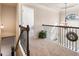 Upstairs hallway featuring neutral carpet, a wrought iron railing and decorative plant at 6280 Stillwood Ln, Cumming, GA 30041