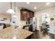 The kitchen includes granite counters, stainless steel appliances, and dark wood cabinets with views into the dining area at 6280 Stillwood Ln, Cumming, GA 30041
