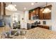 The kitchen features granite counters, a stainless steel stove, and dark wood cabinetry with views into the dining area at 6280 Stillwood Ln, Cumming, GA 30041