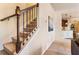 Inviting carpeted staircase with classic wooden railing and view of the eat-in kitchen at 6280 Stillwood Ln, Cumming, GA 30041