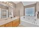 Bright bathroom featuring a large soaking tub, neutral walls, and a spacious vanity with a large mirror at 1332 Kent Mnr, Stockbridge, GA 30281