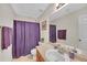 Cozy bathroom featuring a neutral-toned vanity and framed mirror, complemented by a purple shower curtain at 1332 Kent Mnr, Stockbridge, GA 30281