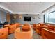 Community theater room with a large flat screen television and ample seating with orange chairs at 860 Peachtree Ne St # 904, Atlanta, GA 30308