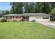 Charming single-story home with brick facade, lush lawn, and attached two-car garage at 1239 Sharonton Dr, Stone Mountain, GA 30083