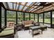 Relaxing sunroom featuring comfortable wicker seating, glass windows, and a ceiling fan at 1239 Sharonton Dr, Stone Mountain, GA 30083