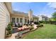 Inviting backyard patio with outdoor seating, flowers, and a lush lawn surrounded by mature trees at 3151 Amesbury Way, Duluth, GA 30096