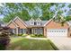 Charming brick home with a well-manicured lawn, black shutters, and attached two-car garage at 3151 Amesbury Way, Duluth, GA 30096