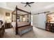Spacious main bedroom featuring a four-poster bed, soft carpet, and a sliding barn door at 3151 Amesbury Way, Duluth, GA 30096
