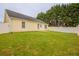 Spacious backyard with lush green grass, white fence, and view of the home's exterior at 4045 Meadow Glen Way, Fairburn, GA 30213