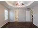 Empty bedroom featuring hardwood floors, a tray ceiling, and two doorways at 4045 Meadow Glen Way, Fairburn, GA 30213