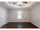 Neutral bedroom featuring hardwood floors, a tray ceiling, and a standard door at 4045 Meadow Glen Way, Fairburn, GA 30213