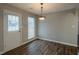 Bright dining area with wood floors, white door and window and decorative light fixture at 4045 Meadow Glen Way, Fairburn, GA 30213