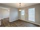 Empty dining room with hardwood floors, a pendant light, and a window at 4045 Meadow Glen Way, Fairburn, GA 30213