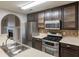 Kitchen with stainless appliances, dark wood cabinets, and an eat-in bar at 4045 Meadow Glen Way, Fairburn, GA 30213