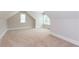 Carpeted attic space with dormer windows, white trim, and neutral paint at 1142 Wiley Bridge Rd, Woodstock, GA 30188