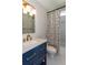 Bathroom with a blue vanity, gold fixtures, and decorative shower curtain at 1142 Wiley Bridge Rd, Woodstock, GA 30188