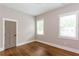 Bedroom featuring hardwood floors, two windows with blinds, and neutral paint at 1142 Wiley Bridge Rd, Woodstock, GA 30188
