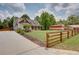 Beautiful two-story home with a sprawling green lawn, fencing, and a long driveway at 1142 Wiley Bridge Rd, Woodstock, GA 30188