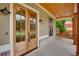 Inviting front porch with wood columns, a cozy porch swing, and a beautiful wood door at 1142 Wiley Bridge Rd, Woodstock, GA 30188