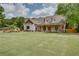 A picturesque two-story home with a spacious lawn and welcoming covered porch with wooden pillars at 1142 Wiley Bridge Rd, Woodstock, GA 30188