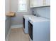 Functional laundry room with modern washer and dryer, storage cabinets, and a folding shelf at 1142 Wiley Bridge Rd, Woodstock, GA 30188