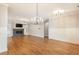 Open-concept living room with hardwood floors, fireplace, wainscoting, and modern lighting at 1142 Wiley Bridge Rd, Woodstock, GA 30188