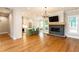 Open living area featuring a modern fireplace, hardwood floors, and seamless connection to the kitchen at 1142 Wiley Bridge Rd, Woodstock, GA 30188