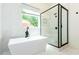 Bright bathroom featuring freestanding tub, glass shower, and modern finishes at 1142 Wiley Bridge Rd, Woodstock, GA 30188