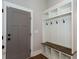 Mudroom featuring built-in storage with hooks, shelves, and a bench, next to a gray paneled door at 1142 Wiley Bridge Rd, Woodstock, GA 30188