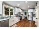 Well-lit kitchen featuring stainless steel appliances, white cabinets, and hardwood flooring at 3087 Dunton Se St, Smyrna, GA 30080