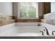 Soaking tub in bathroom with decorative tile surround and large window at 42 Treemont Se Dr, Cartersville, GA 30121