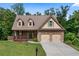 Charming two-story home featuring a brick facade, inviting front porch, well-manicured lawn, and attached two-car garage at 42 Treemont Se Dr, Cartersville, GA 30121