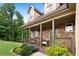 Charming stone home with a cozy covered porch featuring seating and manicured landscaping at 42 Treemont Se Dr, Cartersville, GA 30121