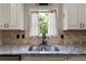 Bright kitchen sink features granite countertops, neutral backsplash, and a window view at 42 Treemont Se Dr, Cartersville, GA 30121