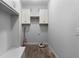 Bright laundry room with upper cabinets and wood-look tile flooring at 42 Treemont Se Dr, Cartersville, GA 30121