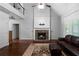 Living room featuring stone fireplace, hardwood floors, and natural light from large windows at 42 Treemont Se Dr, Cartersville, GA 30121